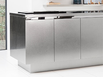 デザインを引き締める鏡面のライン。映り込む光がシンプルなキッチンに多彩な表情をつくります。