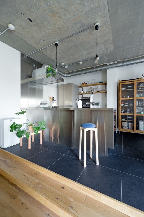 Photo Gallery：はカウンタータイプを採用。スキップフロア上のキッチンとダイニングスペースの床はネイビーの塩ビタイルで空間を引き締めています。