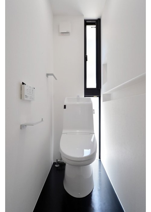 爽やかさを引き締める黒のポイント使いが秀逸なトイレスペース