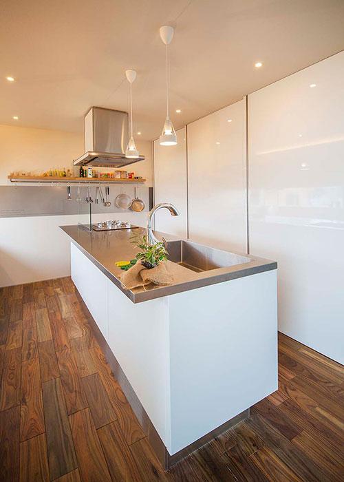 無垢フローリングとの組み合わせがあたたかい雰囲気を醸し出すシステムキッチンの事例