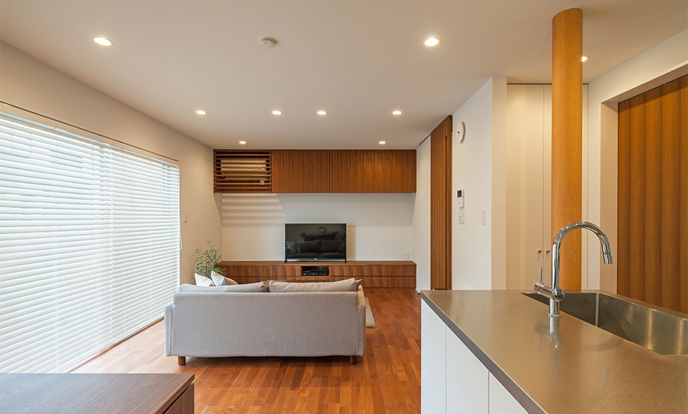 チークのフローリングが味わい深いシステムキッチンとカップボードの事例