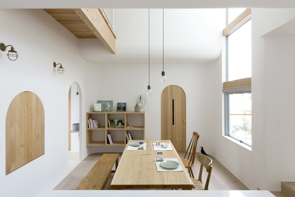 アーチ壁とくすみカラーの洗面ボウルがやわらかな印象をもたらす空間