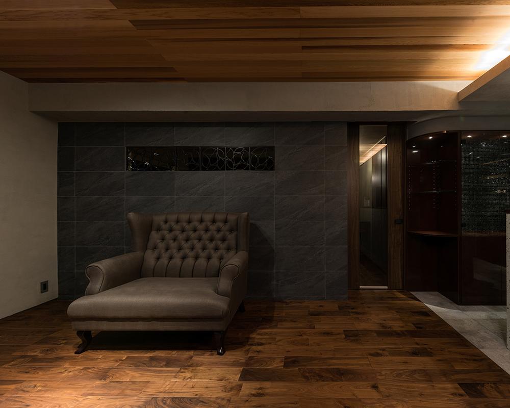 アイアン飾りを埋め込んだ黒ストーン壁のリビング