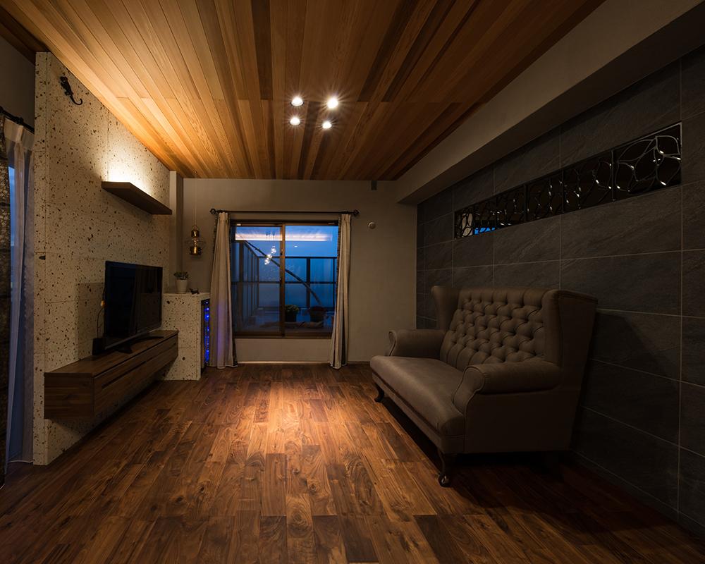 アイアン飾りを埋め込んだ黒ストーン壁のリビング