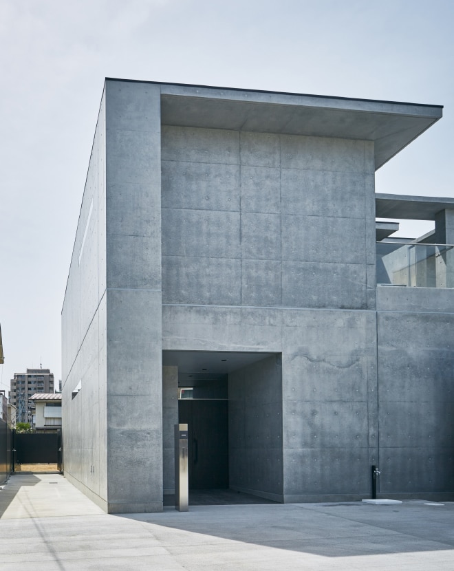 コンクリート打ちっぱなしの壁の中にある玄関