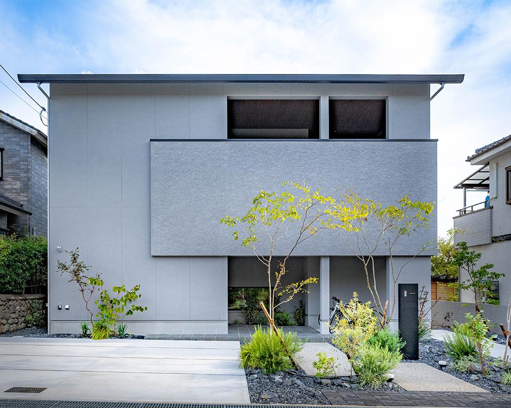 玄関前の吹き抜けと地窓が特徴的な戸建て住宅